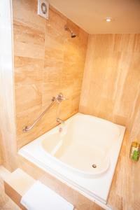 a white bath tub in a bathroom with wooden walls at Bogota Plaza Hotel in Bogotá