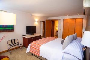 a bedroom with a bed and a flat screen tv at Bogota Plaza Hotel in Bogotá