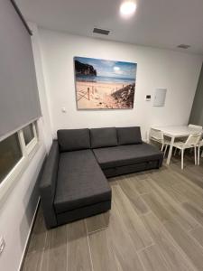 a living room with a couch and a painting on the wall at Apartamentos BEACHYDAYS Metropolis B in Torremolinos