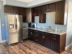 a kitchen with wooden cabinets and a stainless steel refrigerator at Lakeview Condo at Causeway Marina in Naples