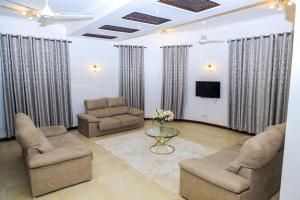 sala de estar con sillas, mesa y TV en a vacation home, en Mbweni