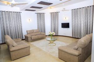 sala de estar con 2 sillas y TV en a vacation home, en Mbweni