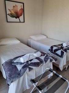 um quarto com duas camas e uma cadeira em Studio aeroporto Congonhas em São Paulo