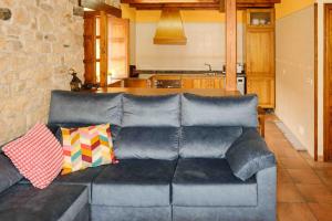 a couch with pillows sitting in a living room at La Bolera Paraíso Astur in Llanes