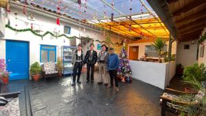 a group of three men standing in a room at Hostal Tunupa in Cusco