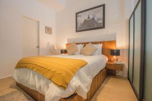 ein Schlafzimmer mit einem großen Bett und einer gelben Decke in der Unterkunft My Place Donceles in Mexiko-Stadt