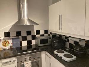 a kitchen with black and white tiles on the wall at Ramilies Homes in Chatham