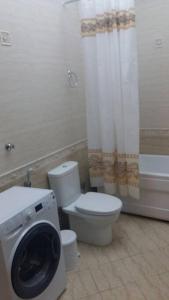 Un baño con inodoro y lavadora. en Classical apartment in heart of Baku, en Baku