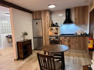 a kitchen with a table and a refrigerator at La Mansión de La Adrada in La Adrada