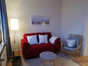 a living room with a red couch and a table at Heimathafen 1 in Grevesmühlen