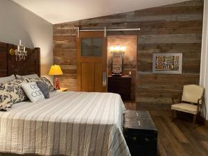 a bedroom with a bed and a wooden wall at Donkeytown at Turner Farms in Heltonville