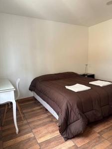 a bedroom with a bed and a table and a desk at Viento del Sur in Ushuaia