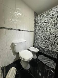 a black and white bathroom with a toilet and a sink at Viento del Sur in Ushuaia