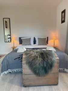 a bedroom with a large bed with a wooden chestituresitures at B&B Villa Navy in Koksijde