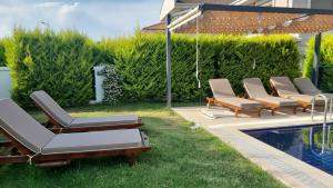 a row of lounge chairs next to a swimming pool at Dalyan Villa Carmen-2 in Dalyan