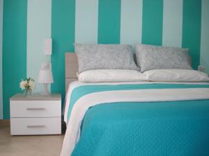 a blue bedroom with a bed and a night stand at B&B Margherita in Marina di Camerota