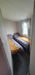 two beds in a small room with a window at R&L'S RETREATS in Cayton