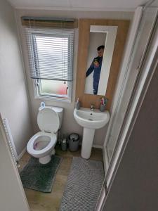 a small bathroom with a toilet and a sink at R&L'S RETREATS in Cayton