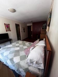 1 dormitorio con 1 cama con manta a cuadros en Azhares, en Copiapó