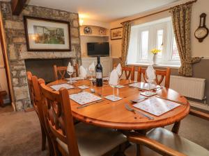 a dining room with a wooden table with a bottle of wine at 26 Tansey in Shepton Mallet