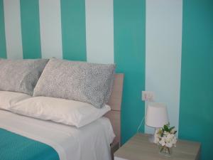 a bed with a pillow and a table with a lamp at B&B Margherita in Marina di Camerota