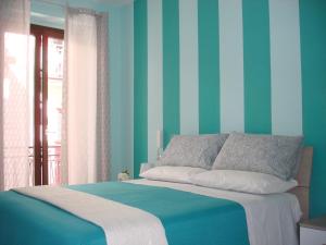 1 dormitorio con 1 cama con rayas azules y verdes en B&B Margherita en Marina di Camerota