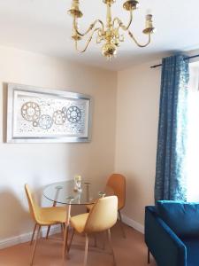 uma sala de jantar com uma mesa e cadeiras e um lustre em Pulteney Road Apartment em Bath