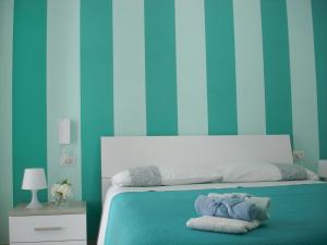 a blue bedroom with a bed with towels on it at B&B Margherita in Marina di Camerota