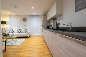 una cucina con lavandino e un divano in una camera di Luxury City Centre Apartment (Weekly Booking) a Hull