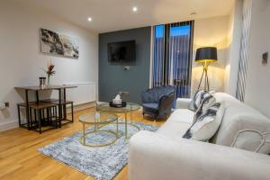 a living room with a white couch and a table at Luxury City Centre Apartment (Weekly Booking) in Hull