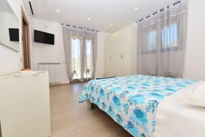 una camera da letto con un letto con una coperta blu e bianca di La Casa di nonna Elena ad Agerola