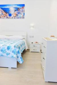 una camera bianca con letto e cassettiera di La Casa di nonna Elena ad Agerola