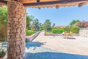 a stone building with a table and chairs on a patio at Villa d'Eos - Granelli, Pachino in Granelli