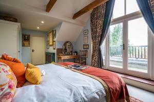 a bedroom with a large bed and a large window at The Anchor Inn in Lower Froyle