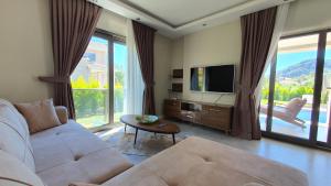 a living room with a couch and a tv at Dalyan Villa Carmen-2 in Dalyan