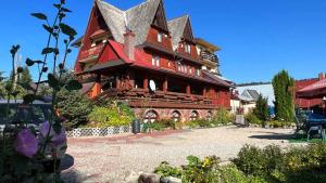 une grande maison en bois avec une grande cour dans l'établissement Kwatery u Papieżów, à Biały Dunajec