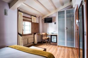 a bedroom with a bed and a desk with a chair at Hotel Alda Bonaval in Santiago de Compostela