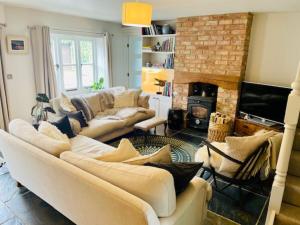 a living room with two couches and a fireplace at Idyllic Country Cottage near Soho, Oxford & Cotswolds in Banbury