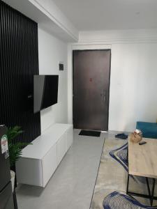 uma sala de estar com um sofá branco e uma televisão em Goldpark home em Nairobi