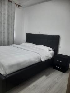 uma cama grande com uma cabeceira preta num quarto em Goldpark home em Nairobi