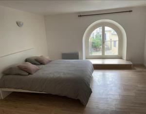 - une chambre avec un grand lit et une fenêtre cintrée dans l'établissement maison proche du château Versailles, à Versailles