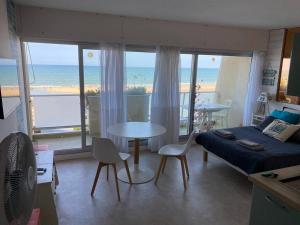 een woonkamer met een bed en een tafel met stoelen bij Studio vue Océan in Lacanau