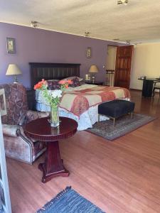 1 dormitorio con cama, mesa y sofá en Azhares, en Copiapó