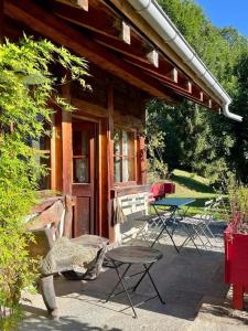 ein Holzgebäude mit einem Tisch und einer Terrasse in der Unterkunft Captivant Chalet T3 vue Panoramique, Chamonix Mont-blanc in Les Houches