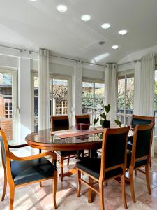 a dining room with a table and chairs and windows at Central Villa with Garden in Ljubljana