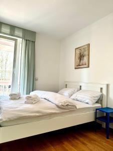 Duas camas num quarto branco com uma janela em Central Villa with Garden em Ljubljana