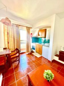 a kitchen with a table and a dining room at Resort Albufeira T1, Praia da Oura in Albufeira