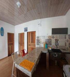 a kitchen with a counter and a table with chairs at Residencial Coqueiros do Sal in Salinópolis