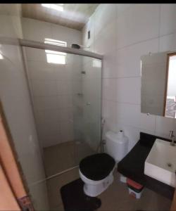 a bathroom with a black toilet and a sink at Residencial Coqueiros do Sal in Salinópolis