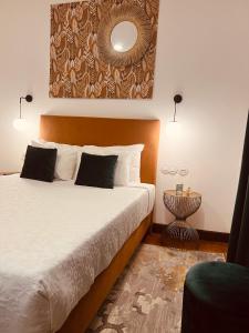 1 dormitorio con cama y espejo en la pared en 145 Townhouse, en Ílhavo